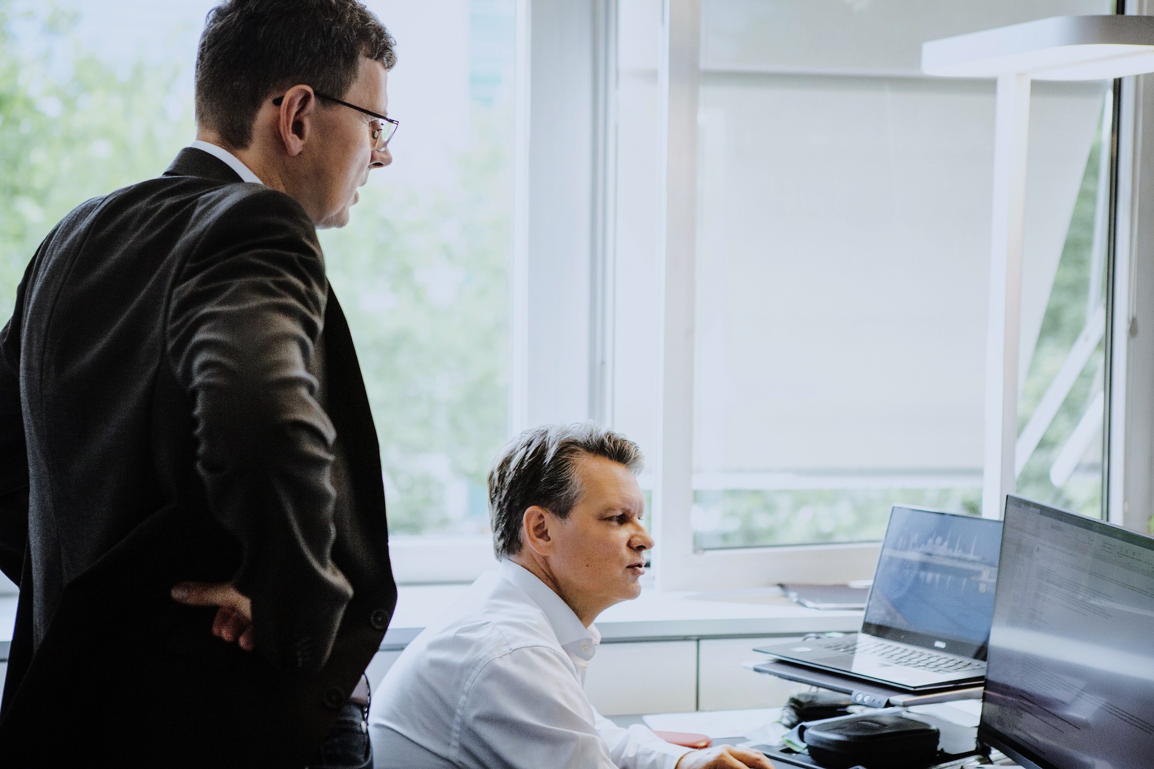 Zwei Personen arbeiten gemeinsam an einem Bildschirm